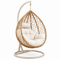 Sillón colgante de ratán sintético beige con cojines extraíbles y estructura de acero
